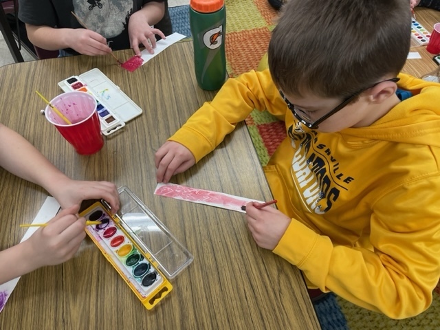 4th graders painting Valentine bookmarks